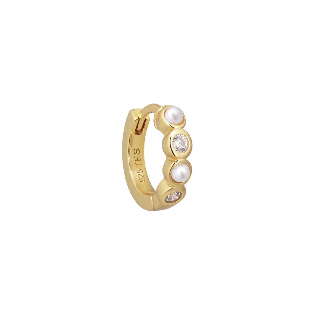 Ellie Huggie Pearlwhite visar ett guldpläterat örhänge med små vita pärlor och klara stenar, modell FW2308.