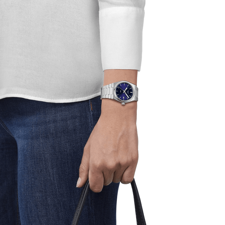 Tissot PRX med blå urtavla sedd på handleden, stålkedja och avslappnad stil, modell T1372101104100.