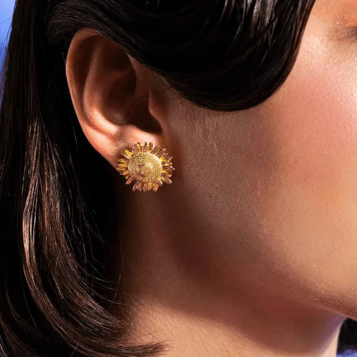 Vincent Mock Meadow Solrosörhängen Guldpläterade visas på örat, detaljerad solrosdesign i guld. Modell VJ130-UEG-1