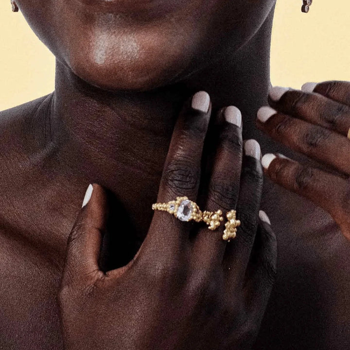 Vincent Orb Chronicles Guldpläterad ring visas på sidan, elegant design med klar sten, modell VJ163-URG-001-2.