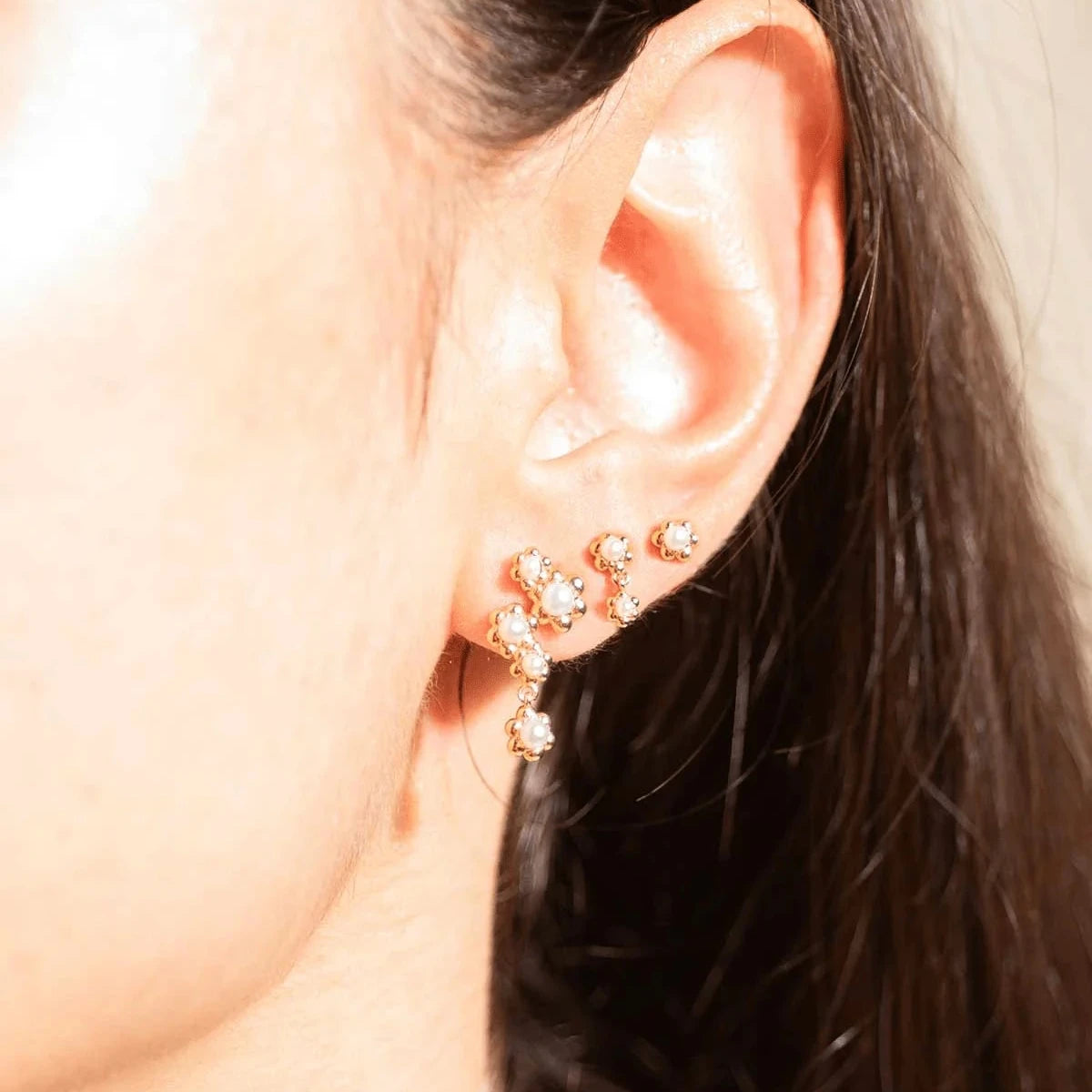 Vincent Venus Bloom Örhängen Guldpläterade Set med 3 örhängen visar tre fina guldpläterade örhängen med vita stenar på örat. Modell VJ246-UEG