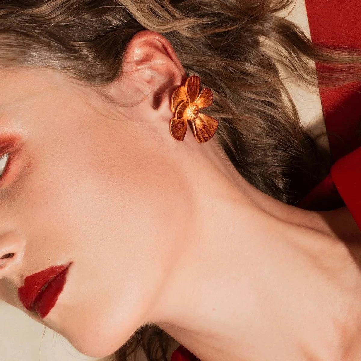 Vincent Wildflower Ample Örhängen Guldpläterade visas på modell, blommönster i gyllene metall. Modell VJ190-UEG-1