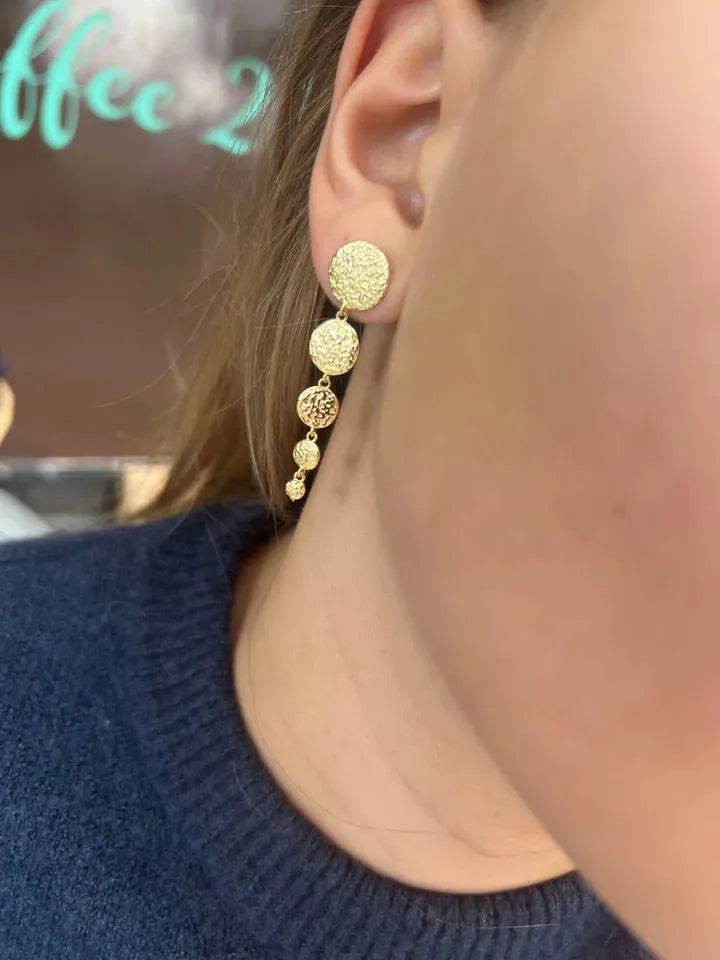 wioga-milena-örhängen-i-guldpläterade-solv-e-8901-gp visar slitna, glänsande guldörhängen med cirkulär struktur. Modell e-8901-gp