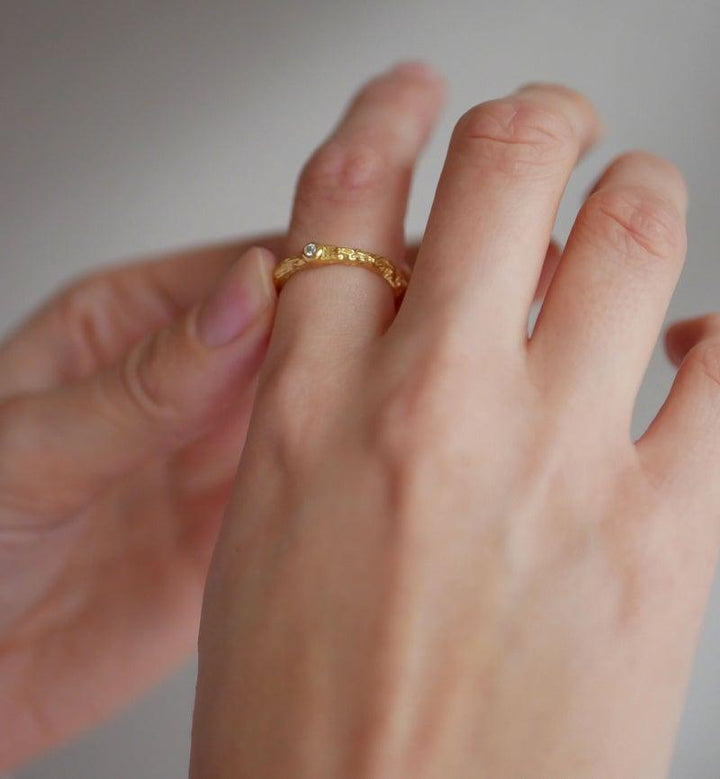 enamel coralle guldpläterad ring bärs på finger, organisk guldfärgad struktur med detalj. Modell R57GM-R57GM-001