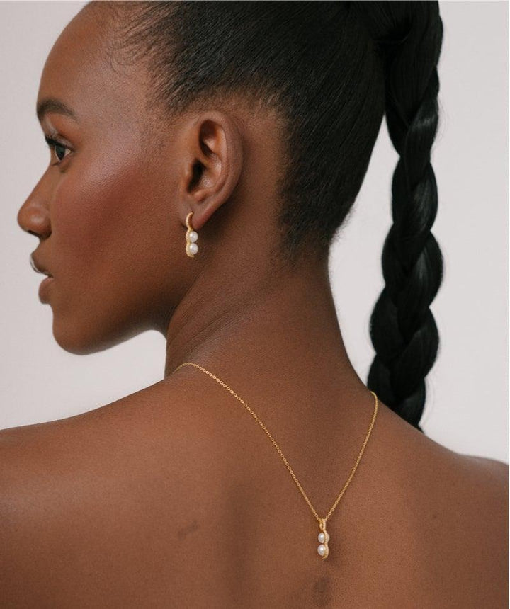Herieth Paul x Polar Jewelry Bahati halsband bärs av modell, elegant guld med pärlor. Modell BAH-NL-GD-WP-WZ-00503-2