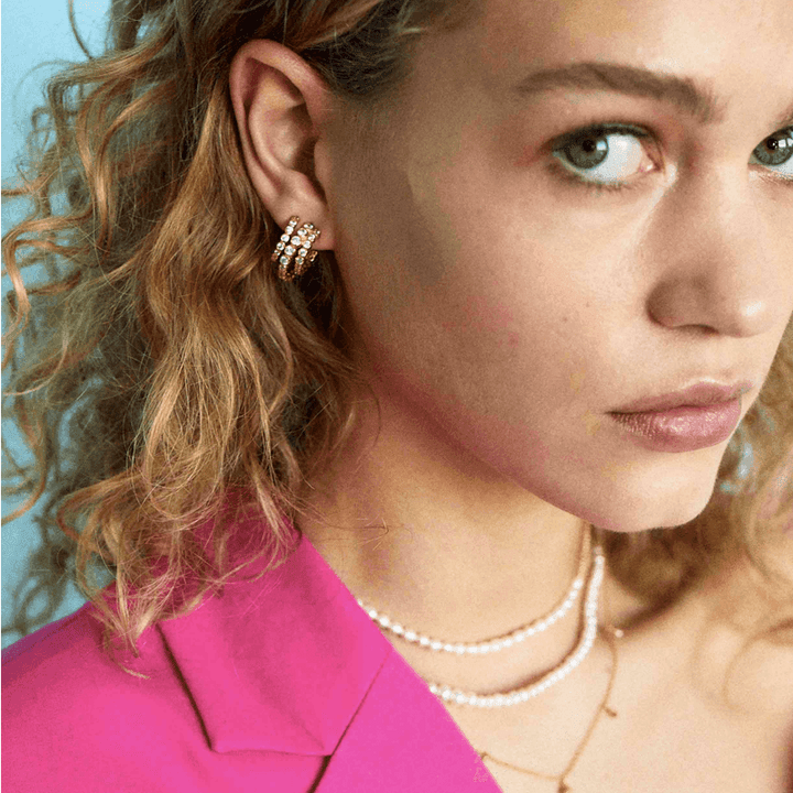 Hultquist Copenhagen Amara Mini Örhängen visas bära i örat, guldlook med klara stenar. Modell S08149G.