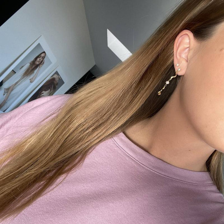 Jeberg Jewellery Ocean Pearl guldpläterat örhänge visat på örat, elegant design med pärl- och gulddetaljer. Modell 51720-2