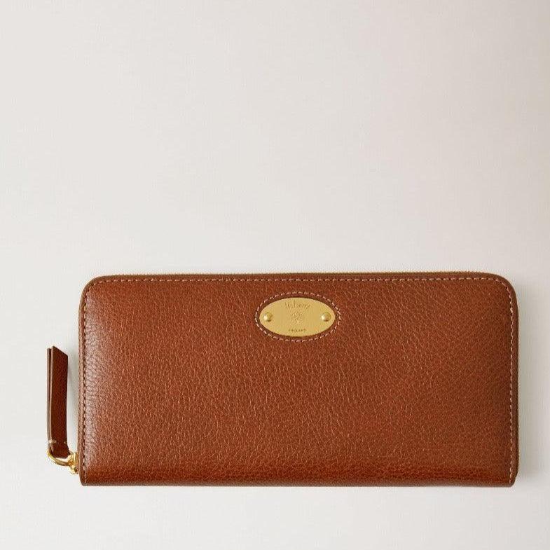 mulberry-plaque-8-cc-zip-purse-legacy i brunt läder med guldfärgad etikett, framifrån. Modell RL7043275G110