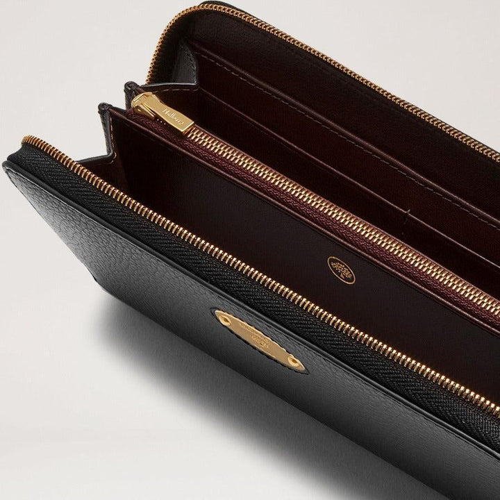 Mulberry Plånbok Plaque 8 Card Zip Purse Small Classic Grain Black visar detaljer av svart läderplånbok med gyllene dragkedja inuti. Modell RL5676013A100.