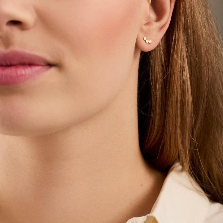 Pernille Corydon Berlin Studs visas på örat, små cirkulära guldörhängen. Modell E-222-GP