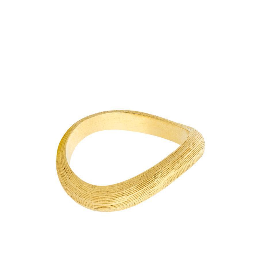 Pernille Corydon Elva Ring visar upp en matt, organiskt formad guldring med räfflad textur. Modell R-249-GP-001-1.