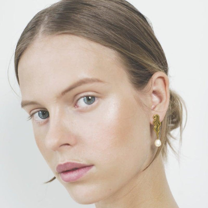 Polar Jewelry The Empress guldpläterade örhängen som visas på modell med pärldetalj och organisk form, modell TEM-HS-GD-WP-00205-2