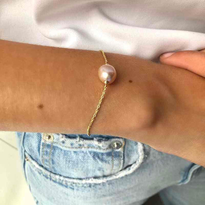 ro copenhagen 18kt joy armband med rosa barock visas runt handleden, elegant guldarmband med pärla. Modell 192l0013-002