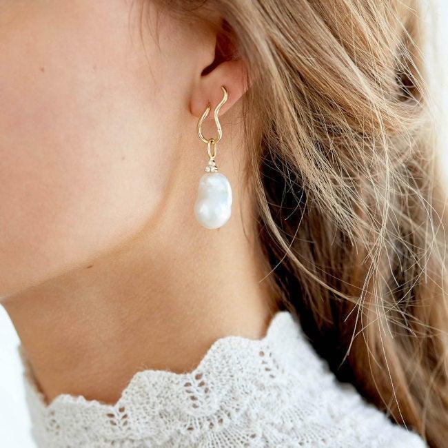 RO Copenhagen 18kt Enjoy Baroque Pearl Pendant visas på örat, vacker barockpärla i gyllene suspension. Modell 106699-2